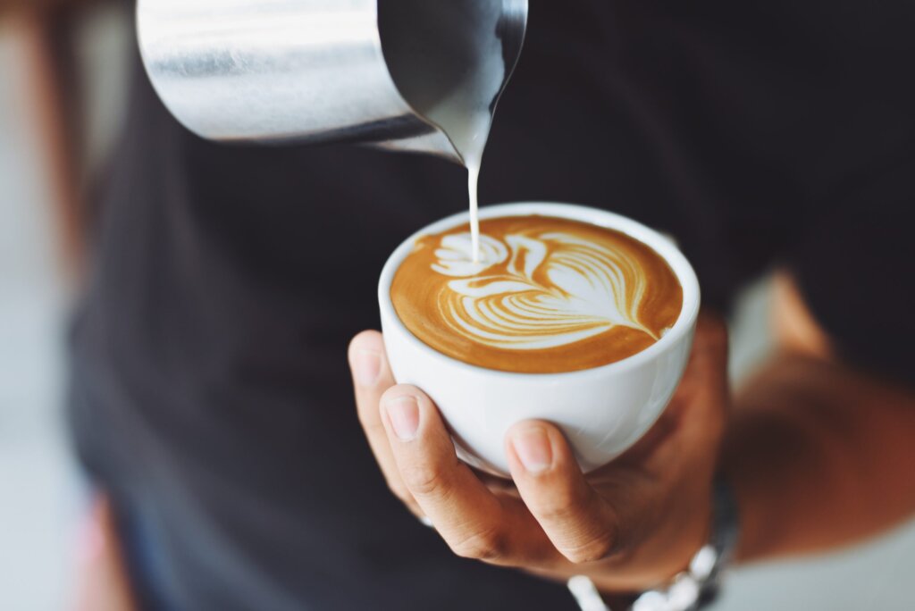 A close-up of a latte with a flower design in the foam