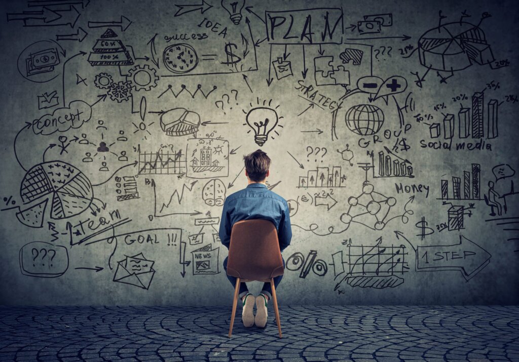 a man sitting in front of a wall of equations